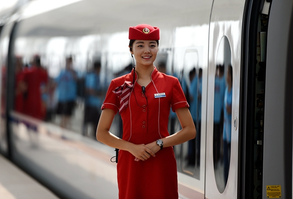 An attendant welcomes passengers to the Zhengzhou-Xuzhou high-speed service in August.Provided To China Daily