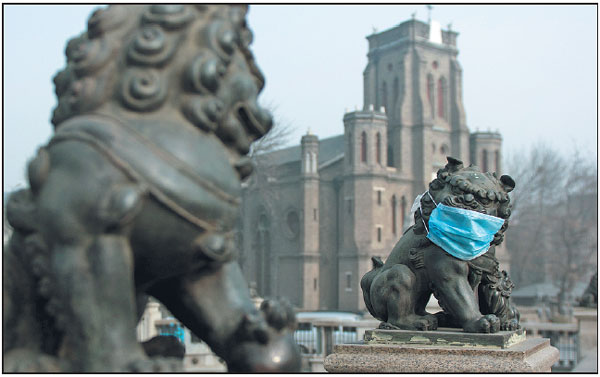 A stone lion on a bridge in Tianjin is covered with a mask in the heavy smog that has hit much of the country's northern regions. (Tong Yu / For China Daily) 