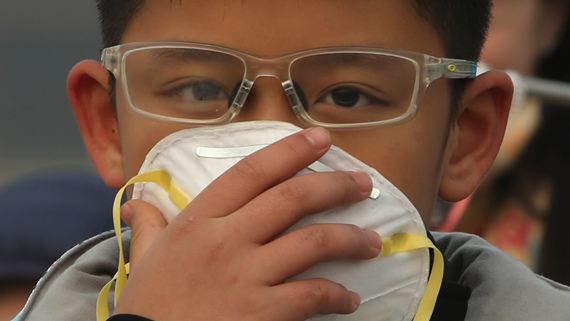 A student covers his nose and mouth with a facial mask. China was shrouded in choking smog throughout the first week of 2017. (Photo/CGTN) 