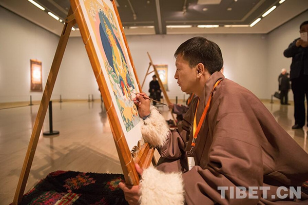 Tibetan Thangka artists are painting at the exhibition's opening ceremony at the National Art Museum of China, Beijing, Jan. 7, 2017. (Photo/Tibet.cn) 