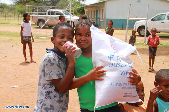 Children carry a bag of rice in Dordabis farm, Khomas Region, central Namibia, on Jan. 11, 2017.  (Xinhua/Wu Changwei)
