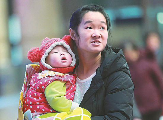 A mother and her baby girl are ready to board a train at Beijing West Railway Station on Friday.