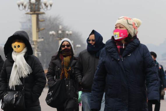 People wear masks at Tian'anmen Square in Beijing on Monday after the city issued a yellow alert for air pollution. (Photo/China Daily)