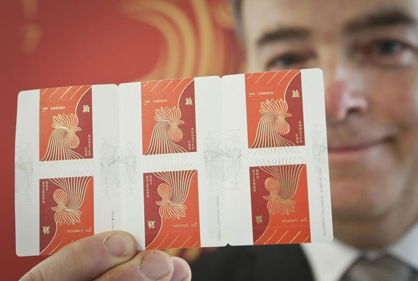 A staff member shows the rooster stamps in Vancouver, Canada, Jan 10, 2017. (Photo/Xinhua)