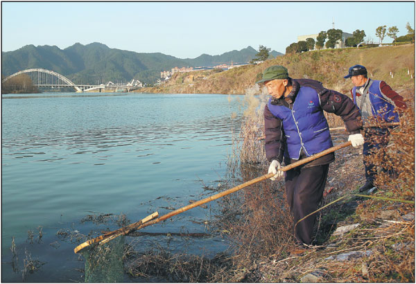 Workers remove rubbish from the Xiuhe River near the center of Xiushui, a county in East China's Jiangxi province. In December, the central government released a document ordering the river chief system, which is linked to performance evaluations of top officials, to be established nationwide by the end of 2018.Hou Liqiang / China Daily