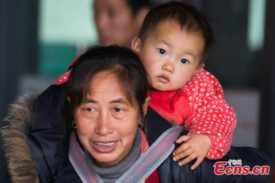 A woman carries a baby at a railway station in Fuzhou City, East Chinas Fujian Province, Jan. 13, 2017. Children are among millions of passengers on their way to hometowns for Spring Festival, Chinas Lunar New Year. (Photo: China News Service/Li Nanxuan)