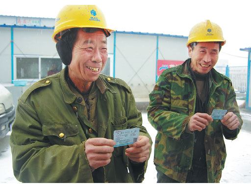 Construction workers in Tianjin hold train tickets for the Spring Festival, which falls on January 28. Migrant workers account for the majority of travelers during the holiday exodus.Photos Provided To Chinadaily