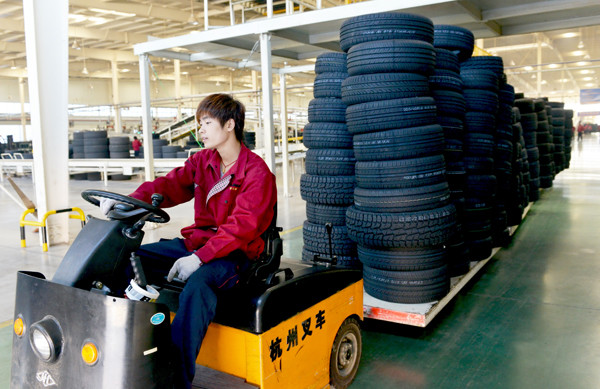 A worker drives a cart loaded with tires at Wanda Rubber Co Ltd in Dongying, Shandong province. (Photo provided to China Daily)