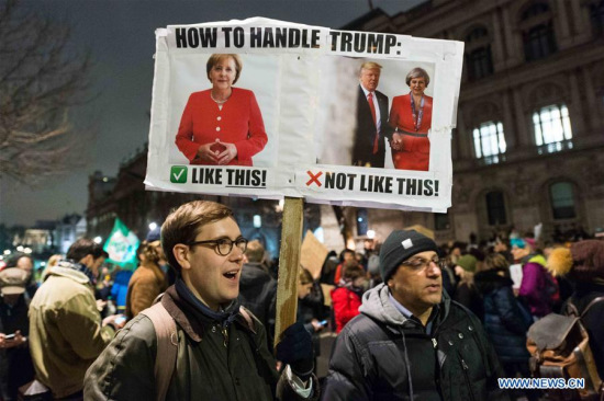A demonstrator holds a placard as thousands gather outside Downing Street in London, Britain, to protest against U.S. President Donald Trump's executive order temporarily barring all refugees and seven Mideast and North African countries' citizens from entry into the United States, on Jan. 30, 2017. (Xinhua/Ray Tang)