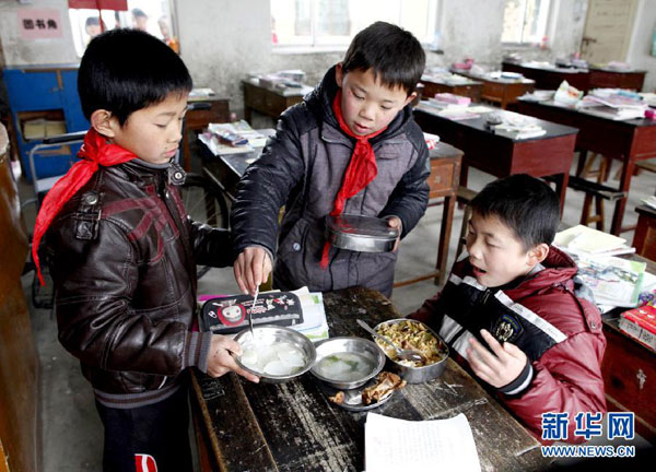 Students eat lunch with Cheng Dongdong at the primary school at Qiucun town in Guangde county, East China's Anhui province, on Feb 29, 2012. (Photo/Xinhua)