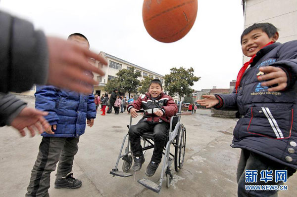 From his wheelchair, Cheng Dongdong plays basketball with his classmates at the primary school at Qiucun town in Guangde county, East China's Anhui province, on Feb 29, 2012. (Photo/Xinhua)