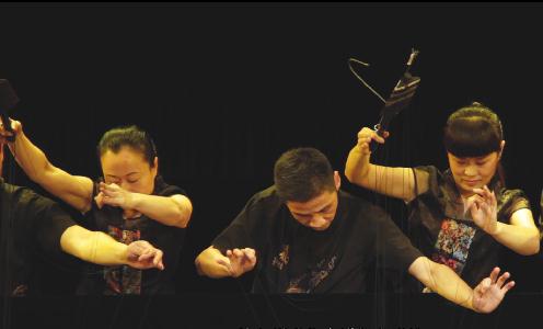 Member of the troupe play the puppets behind a curtain.