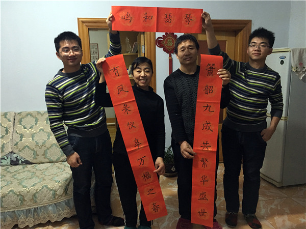 The whole family pose with Spring Festival couplets written by the younger Zhang Chao at their home in Jiaohe city, Northeast China's Jilin province, Jan 24, 2017. (Photo by Jin Dan/chinadaily.com.cn)