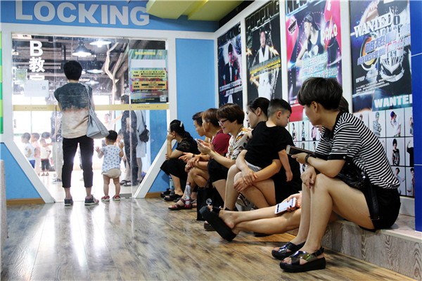 Parents wait for their children who are taking dancing class in Jinhua city, Zhejiang province. Private tuition costs not just money, but also time and energy.Shi Bufa / For China Daily