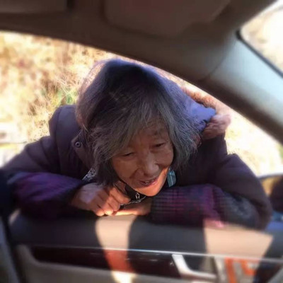 Zhou's mother probes her head into the car to exhort her son. (Photo/Qianjiang Evening News)