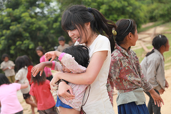 Su Yingle plays with a local child. (Photo provided to China Daily)