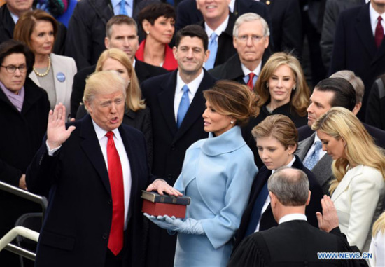 U.S. President Donald Trump(L) takes the oath of office during the presidential inauguration ceremony at the U.S. Capitol in Washington D.C., the United States, on Jan. 20, 2017. Donald Trump was sworn in on Friday as the 45th President of the United States. (Xinhua/Yin Bogu)