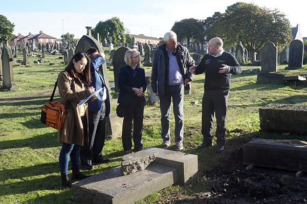 Members of an inspection team from the China Foundation for Cultural Heritage Conservation discuss restoration plans with a memorial stonemason and local councillors in Newcastle-upon-Tyne, England. (Photo: ZHANG RONG/CHINA DAILY)