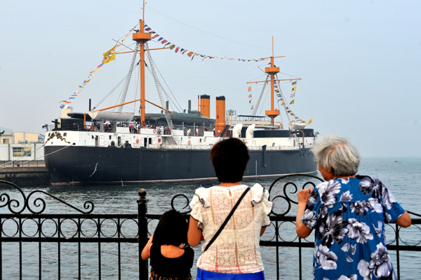 Tourists examine a model of the Dingyuan, a member of the Beiyang Fleets, in Weihai, Shandong province. (Photo/Xinhua)