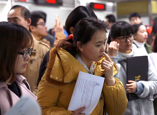 College students attend a job fair in Beijing on Monday. There are expected to be nearly 8 million new graduates in China this year.(Photo/China Daily)
