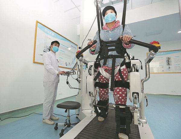 A patient walks with the help of a rehabilitation robot in a hospitalin Xiangyang, Hubei province, in 2016. YANG DONG / FOR CHINA DAILY