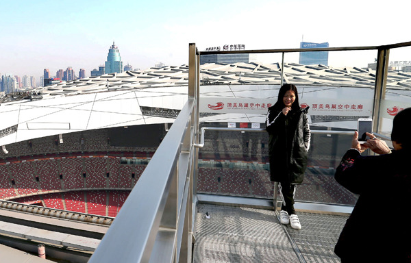 A visitor takes photos on the sightseeing platform of National Stadium's roof corridor on Sunday. (Photo by Wang Zhuangfei/China Daily)