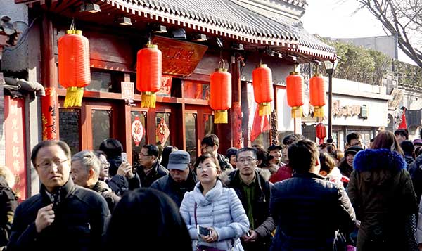 Visitors stroll through Nanluoguxiang, a popular alleyway in Beijing, after the completion of a renovation project earlier this month.(Photo by Li Xin/Xinhua)