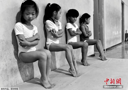 Four students of a gymnastics school in Xuzhou, China, do toe-pressure training for 30 minutes in the afternoon. (Photo/Agencies)