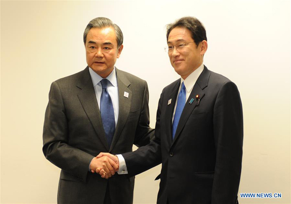 Chinese Foreign Minister Wang Yi (L) shakes hands with his Japanese counterpart Fumio Kishida during their meeting on the sidelines of the Group of Twenty (G20) ministerial meeting in Bonn, Germany, on Feb. 17, 2017. (Xinhua/Yan Feng)