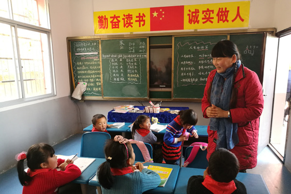 Zhi Yueying gives a Chinese lesson to students at the primary school in Baiyang, Fengxin county, in Jiangxi province. (Photo by Wang Jian/China Daily)