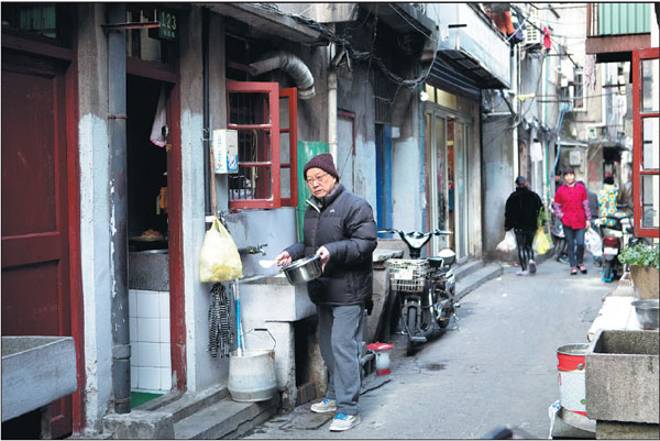 A Zhangqiao resident cleans pots and pans at an outdoor sink in the community.Gao Erqiang/china Daily