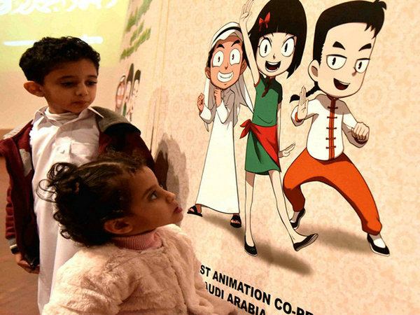 Two Saudi Arabian children look at the poster for the animation series Kong Xiaoxi and Hakim, Feb. 22, 2017. (Photo/Xinhua)