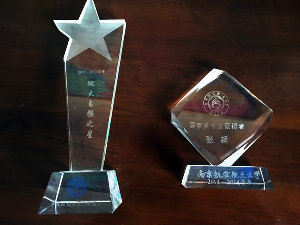 Left: A trophy awarded to the younger Zhang Yue for his persistence in hardship and outstanding academic performance. Right: A trophy certifying the elder Zhang Chao as the winner of Naitonal Scholarship. (Photo by Jin Dan/chinadaily.com.cn)