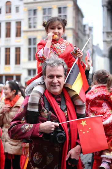 A Belgian man and his daughter wear Tangzhuang, a traditional Chinese suit featuring typical Chinese embroidery, at a Chinese New Year celebration event. (Photo by Zhang Miaojing)