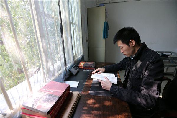 Qin Yuefei studies at his office. (Photo by Wang Zhuangfei/China Daily)