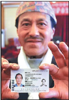 Tuladhar Ratna Kumar, a Nepalese citizen, shows his permanent resident's permit on Wednesday. (Photo/China Daily)