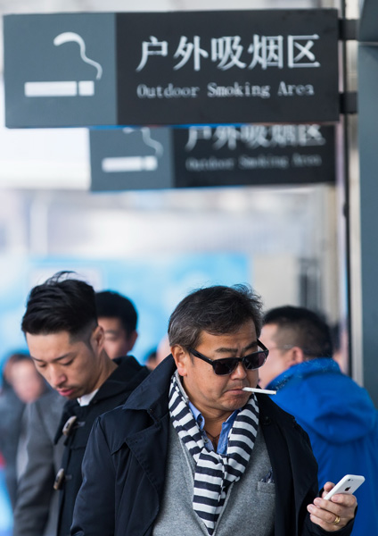 A man smokes at Shanghai Hongqiao Railway Station. (Photo/China Daily)