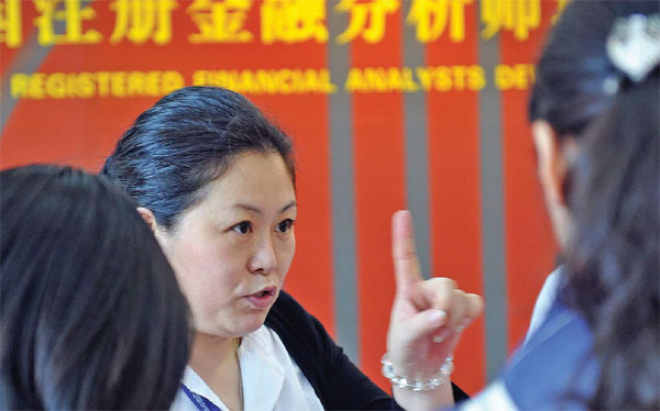 A chartered financial analyst offers investment advice to prospective clients at an international financial expo in Shenzhen, Guangdong province. (Provided to China Daily)