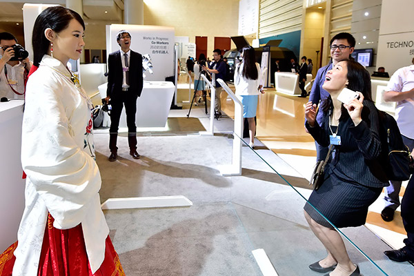 A woman visitor laughs when humanoid robot Jia Jia made a correct guess about her age at an expo in Tianjin. Jia Jia uses voice recognition technology developed by iFlytek Co Ltd, a software company specializing in intelligent speech and language technologies. (Photo/Xinhua)