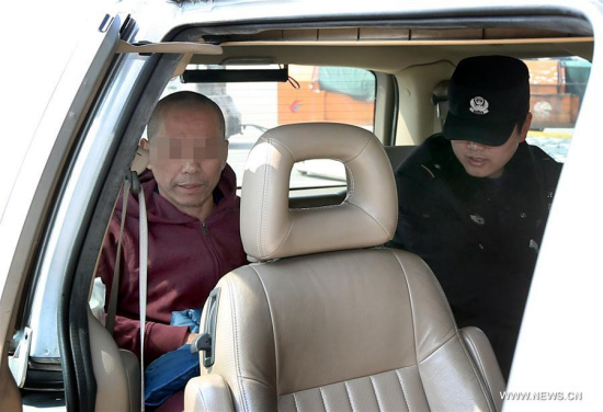 Police officers escort a fugitive into a vehicle at Pudong International Airport in east China's Shanghai, March 8, 2017. (Xinhua/Fan Jun)