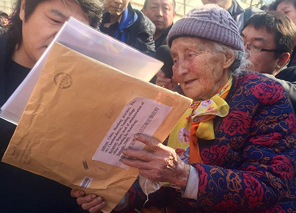 A translator reads letters to Liu Molan in Zibo, Shandong province, on Wednesday. The letters were sent by Oleg Kuvshinnikov, governor of Russia's Vologda Oblast, where Liu was born, and local children.Zhao Ruixue / China Daily