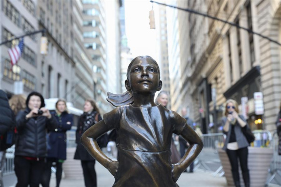 Photo taken on March 9, 2017 shows the fearless girl statue facing the bronze bull statue near the Wall Street in New York, the United States. (Xinhua/Wang Ying)