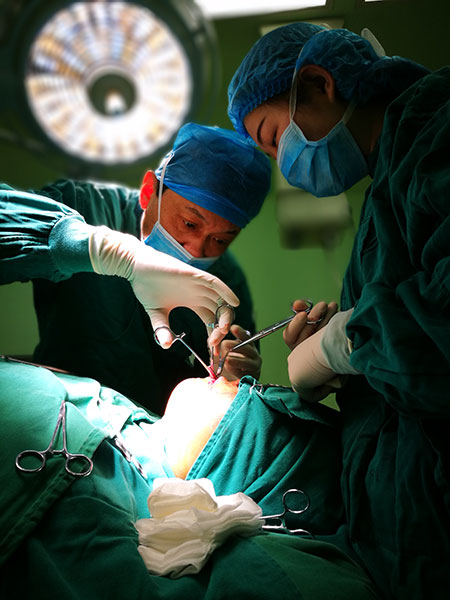 Doctors in Wuhan perform surgery on Zhao Xuecheng, who was badly burned as an infant. Photo/China Daily)