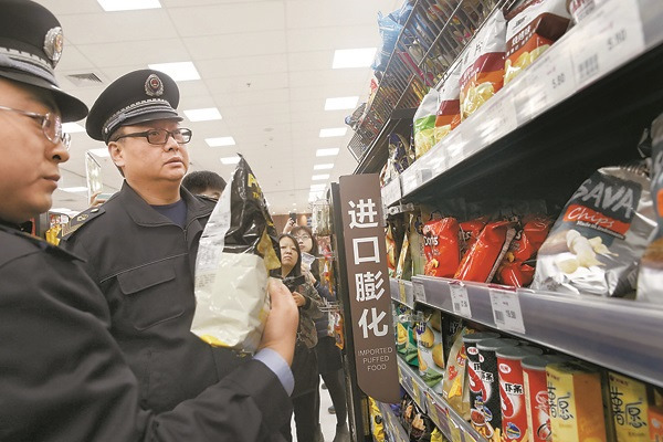 Officers from the Beijing Food and Drug Administration check imported food at a supermarket on Thursday. (Photo/CHINA DAILY)