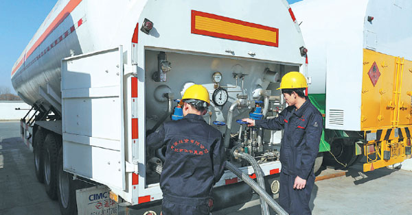 Workers check the operation of a natural gas station in a village in Beijing's Fangshan district early this month. Zhu Xingxin / China Daily