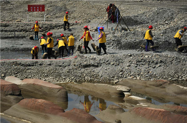 Excavation workers conduct archaeological investigations on a riverbed of the Minjiang River in Meishan, Sichuan province, on the weekend. More than 10,000 relics have been unearthed since January. Photos Provided to China Daily