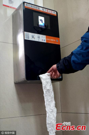 A machine on the wall requires people to scan their faces first before they can get free toilet paper in Tiantan Park, Beijing, March 19, 2017. Tiantan Park, home to the iconic Temple of Heaven, used the machine to prevent users from raiding the park's restrooms for toilet paper. The software will deny the same person toilet paper within nine minutes of their first scan. (Photo/CFP)