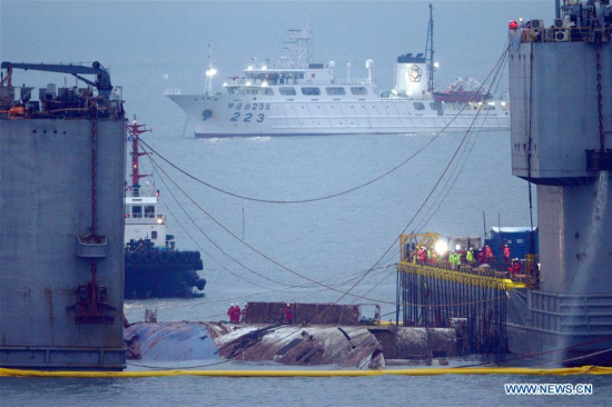 The sunken passenger ferry Sewol is raised during its salvage operations on the sea off Jindo Island,South Korea, March 23, 2017.(Xinhua/NEWSIS) 