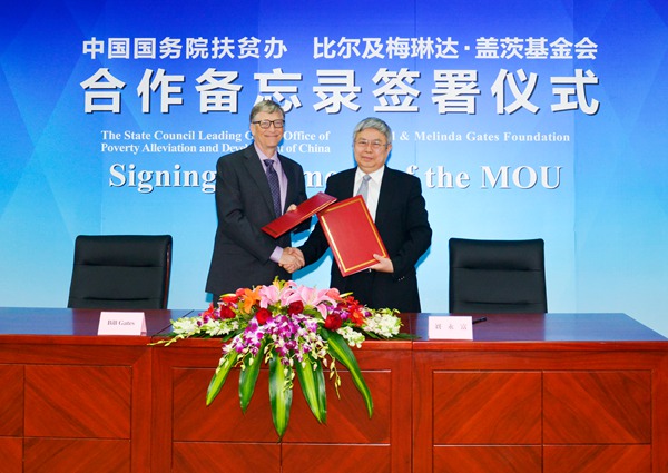 Billionaire business magnate Bill Gates (L) shakes hands with Liu Yongfu, head of the State Council Leading Group Office of Poverty Alleviation and Development, after they sign a memorandum of understanding on Friday to deepen cooperation in China's ongoing nationwide campaign of poverty relief. (Photo provided to chinadaily.com.cn)