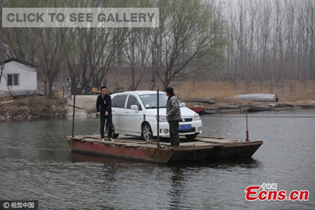 Li Lian uses his ferry boat to transport a car over the Chaobai River, which is about 50 meters wide, in Yanjiao, Heibei Province, March 20, 2017. Li Lian says the demand for transporting cars with his boat has increased dramatically in the past five years. He starts to work at 6 am. It's 1 yuan ($0.14) for a person to take the boat, 2 yuan for bicycle or electric bike and 10 yuan for a car to cross the river. Li Lian and his nephew earn about 3,000 yuan a month. (Photo/CFP)